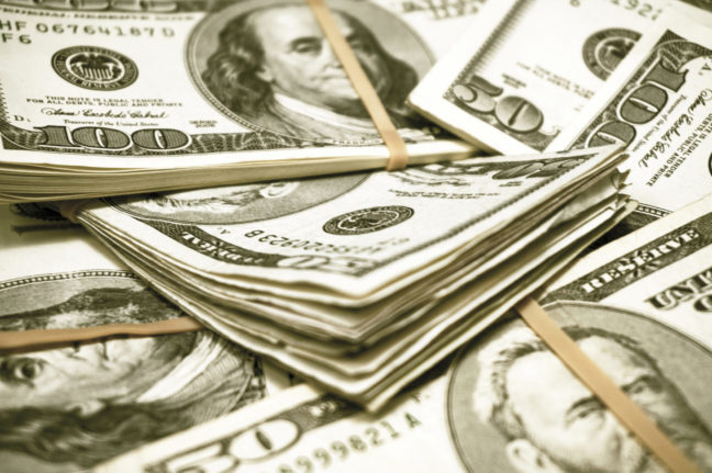 $50 bills banded together with rubber bands in a pile