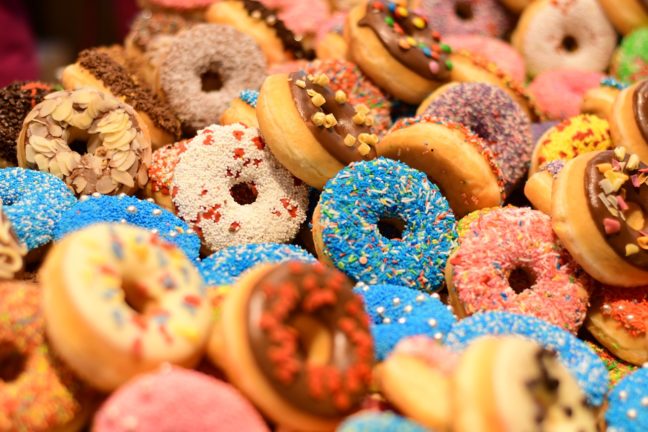 Dozens of decorated donuts in rows